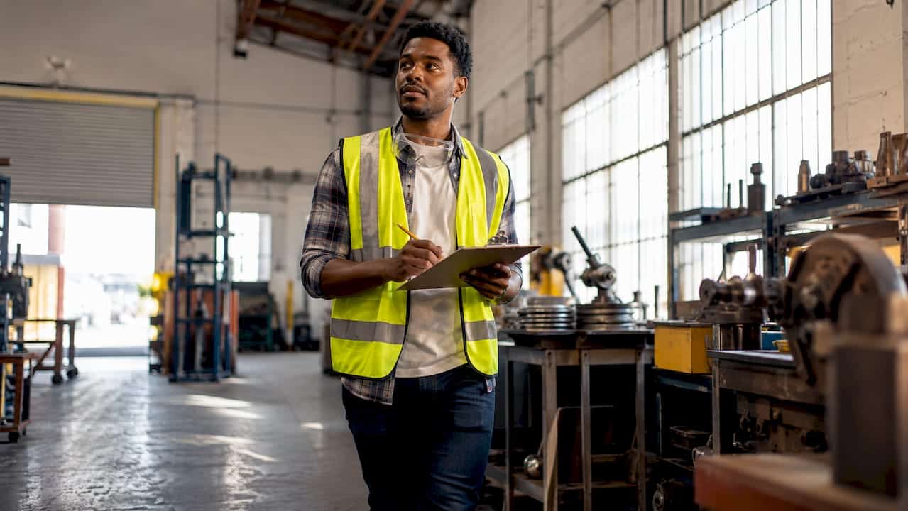 Employee documenting hazards in warehouse